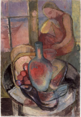 Frau hinter Tisch mit Weinkaraffe und Fruchtkorb