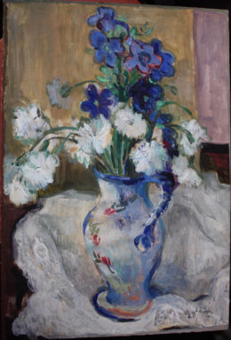 Weißblauer Blumenstrauß in bemalter Vase auf weißem Tuch