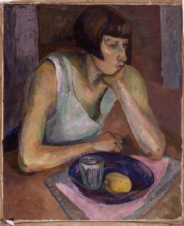 Frau am Tisch sitzend mit blauer Schale
