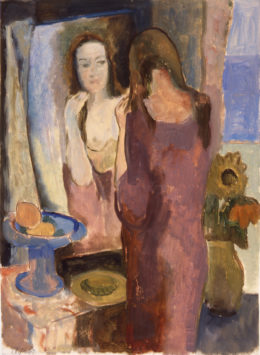 Eine Frau betrachtet sich im Spiegel